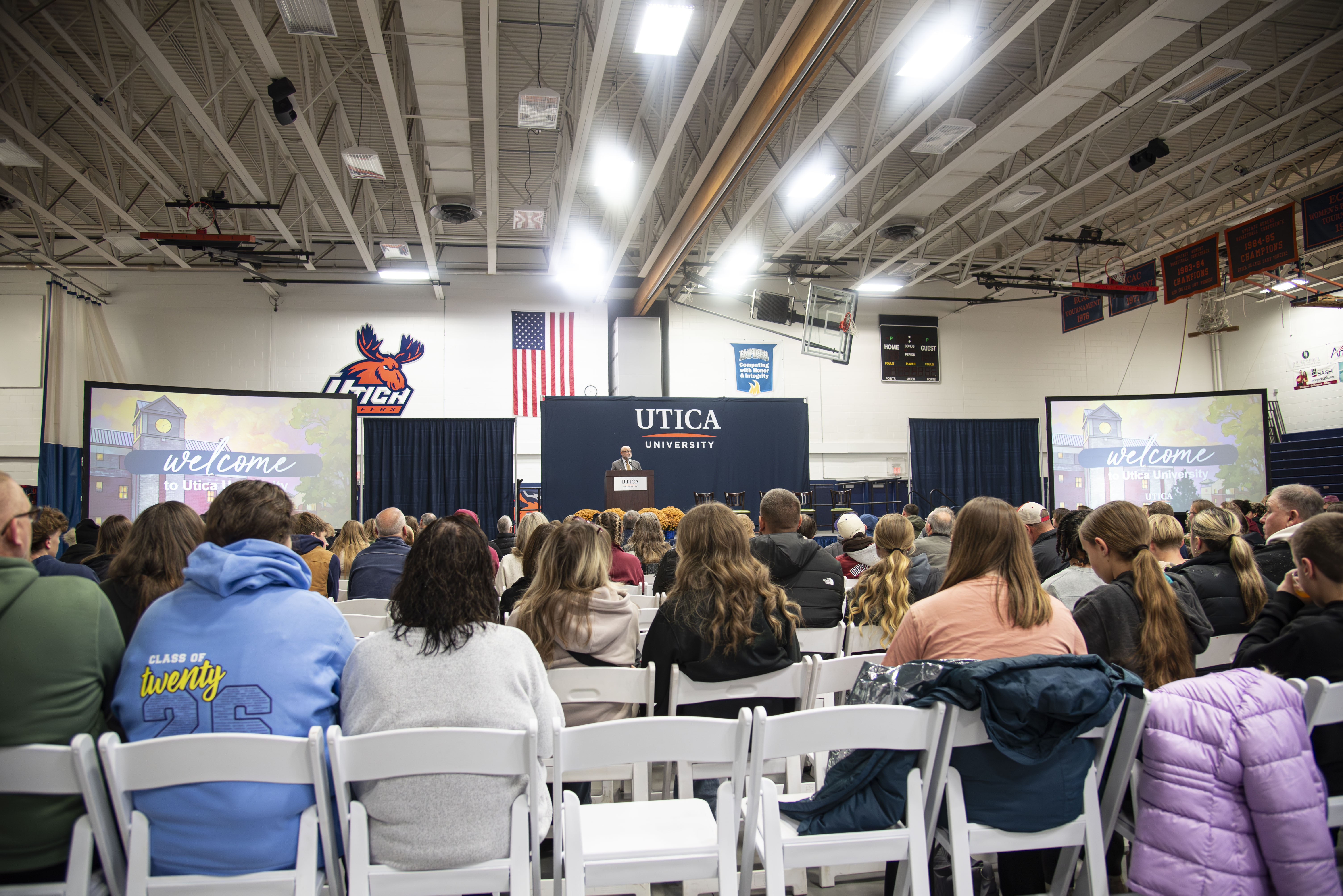 Students and families in rows of chairs, are greeted by members of the Utica community at a November 2025 Open House event.