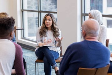 Woman addresses group in counseling session.
