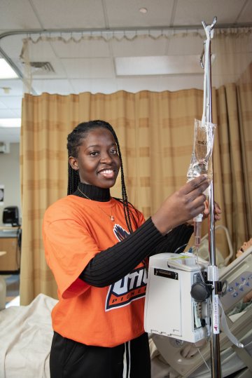 Lois Mensah handles an IV bag in the Nursing Lab.
