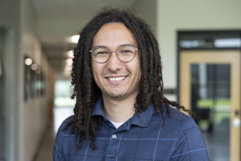 Stephen Banks, with shoulder-length hair, glasses and wearing a blue polo shirt.