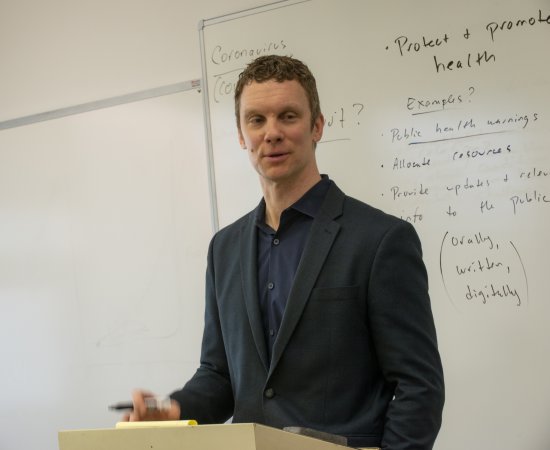 Luke Perrry at a lectern in the classroom.